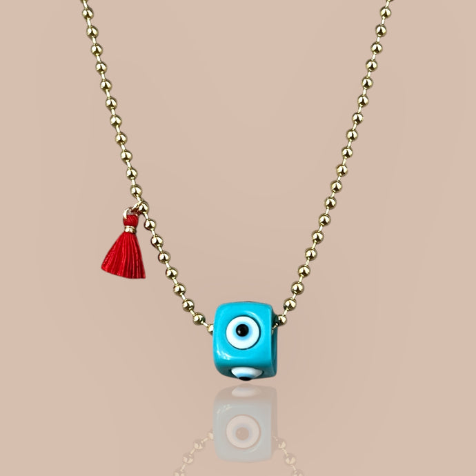 Gold ball chain necklace with turquoise cube pendant featuring an evil eye symbol, representing protection and elegance.