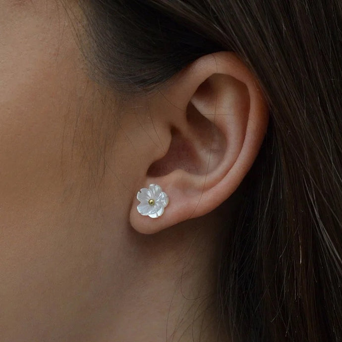 Model wearing the earrings, showcasing their elegant daisy design.