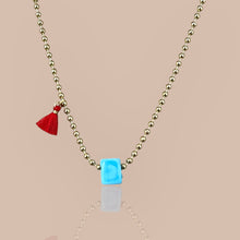 Load image into Gallery viewer, Close-up of a gold beaded chain necklace with a turquoise cube pendant, symbolizing luck and elegance
