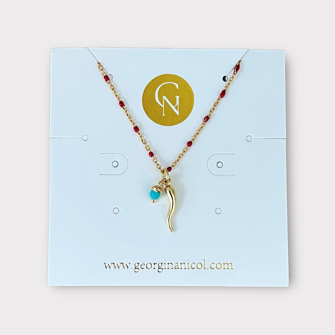 
Close-up of Gold Cornicello Red Enamel Beaded Necklace on a white background.