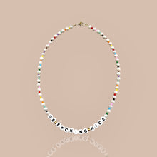 Load image into Gallery viewer, Close-up of Be Nice Pearl Necklace with multicolor beaded spacers, showcasing the positive message and vibrant design.
